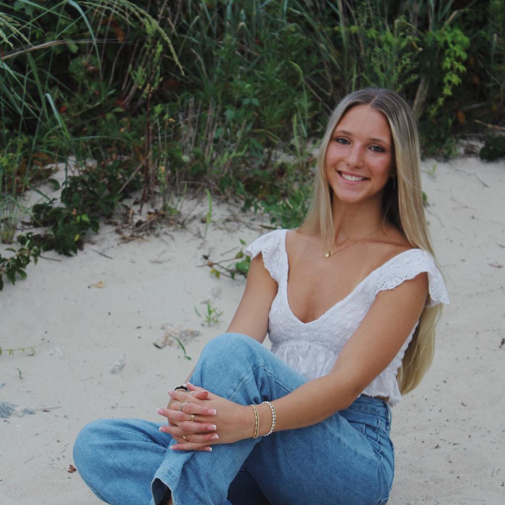 rori holland sitting on beach